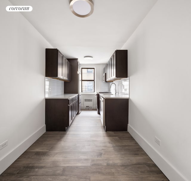 kitchen featuring tasteful backsplash, radiator heating unit, and dark brown cabinetry