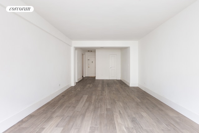 unfurnished room with wood finished floors, visible vents, and baseboards