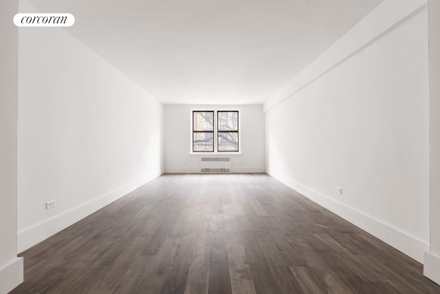 empty room featuring radiator and dark wood-type flooring