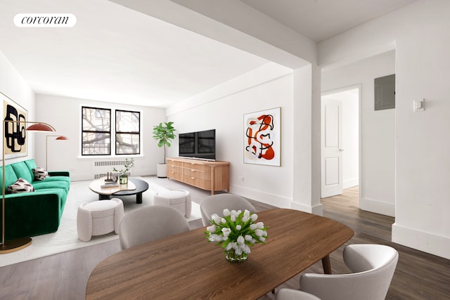 living area featuring visible vents, radiator heating unit, wood finished floors, electric panel, and baseboards