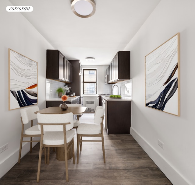 kitchen with dark brown cabinetry, backsplash, radiator heating unit, and dark hardwood / wood-style floors