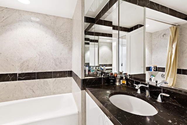 bathroom with vanity, shower / tub combo, and tile walls