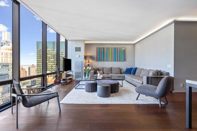 living room featuring dark wood-type flooring and a wall of windows