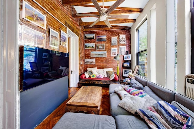 sitting room with ceiling fan, brick wall, and lofted ceiling with beams