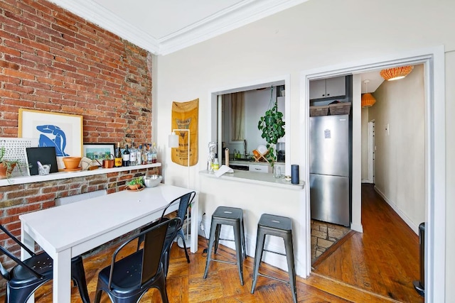 kitchen featuring brick wall, parquet floors, stainless steel refrigerator, and crown molding