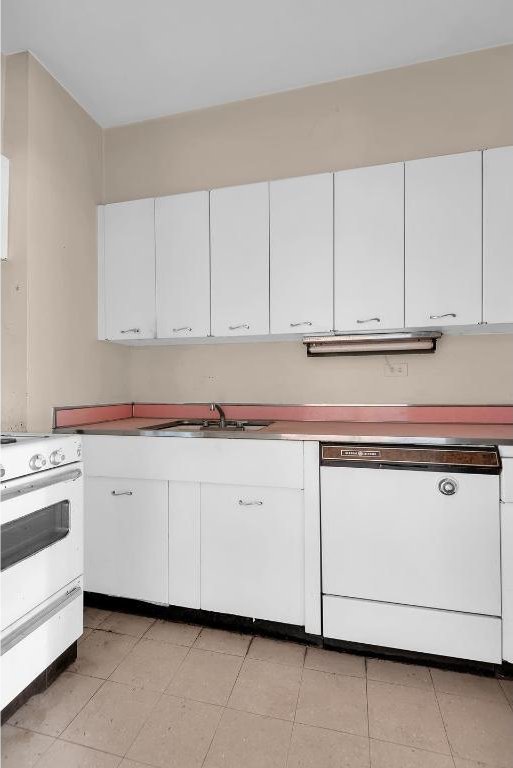 kitchen featuring white appliances, sink, and white cabinets