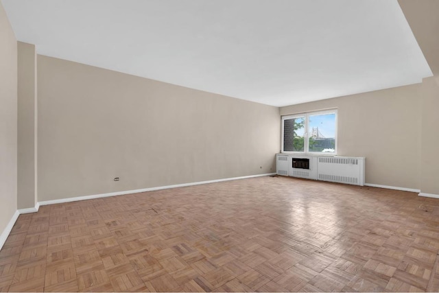 unfurnished living room with radiator heating unit and light parquet flooring