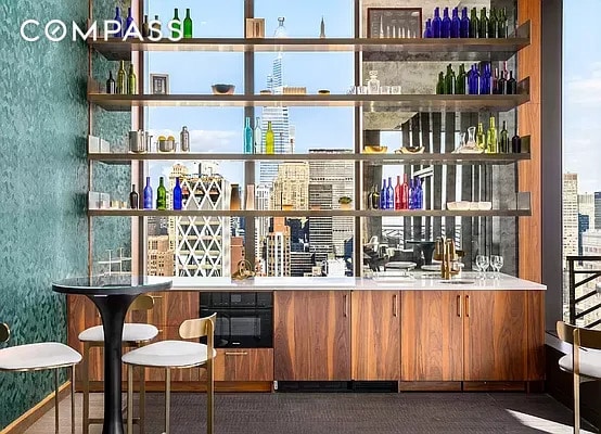 bar with a sink, black oven, wallpapered walls, and wet bar