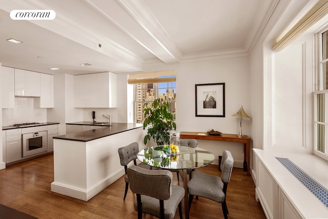 kitchen featuring sink, dark wood-type flooring, white cabinets, and stainless steel gas cooktop