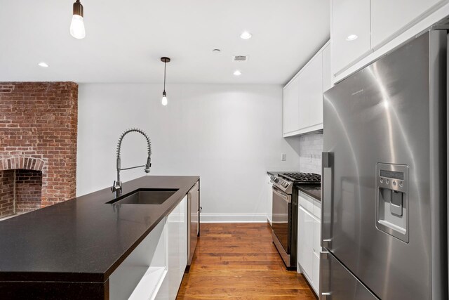 5 W 120th St Unit 1, New York City, NY 10027 - kitchen featuring appliances with stainless steel finishes, dark countertops, a sink, white cabinetry, and dark wood-style floors