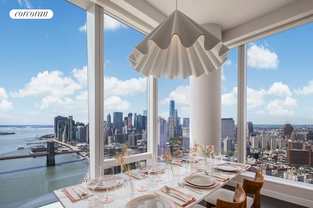 dining room featuring a view of city, a water view, and a healthy amount of sunlight