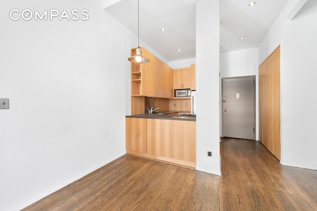 kitchen featuring dark countertops, stainless steel microwave, dark wood-type flooring, modern cabinets, and open shelves