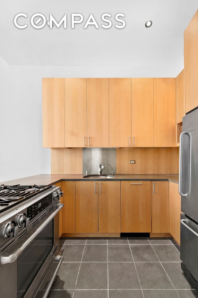 kitchen featuring backsplash, dark tile patterned floors, recessed lighting, stainless steel appliances, and a sink