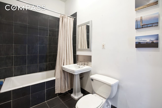 bathroom with tile patterned flooring, toilet, and tiled shower / bath combo