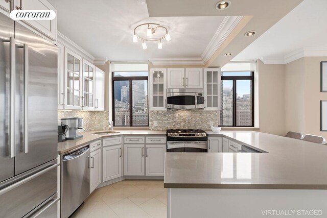 kitchen featuring ornamental molding, appliances with stainless steel finishes, white cabinets, and backsplash