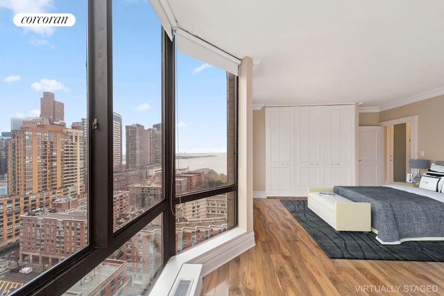 bedroom featuring hardwood / wood-style floors, ornamental molding, and expansive windows