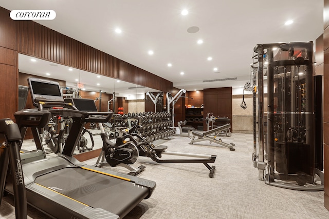 gym featuring light colored carpet, visible vents, wood walls, and recessed lighting