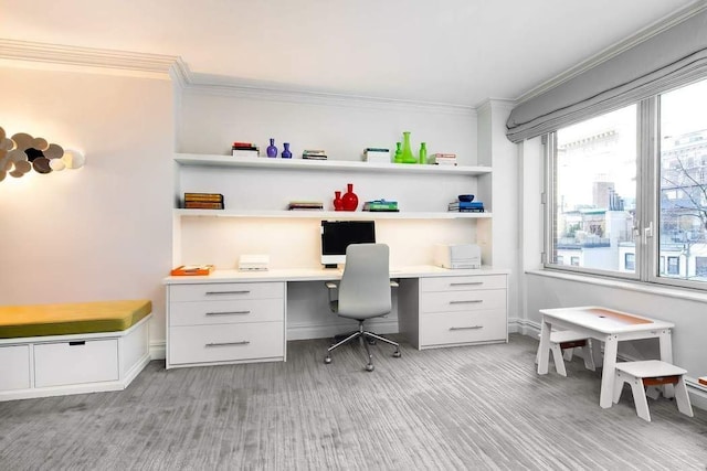 office area featuring built in study area, baseboards, and ornamental molding