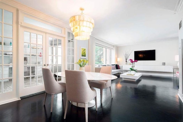 dining room with ornamental molding, a notable chandelier, dark hardwood / wood-style flooring, and french doors