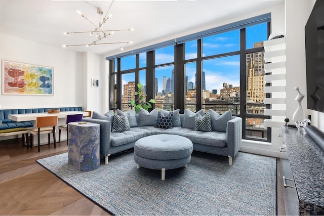 living room with plenty of natural light, a notable chandelier, and dark parquet floors