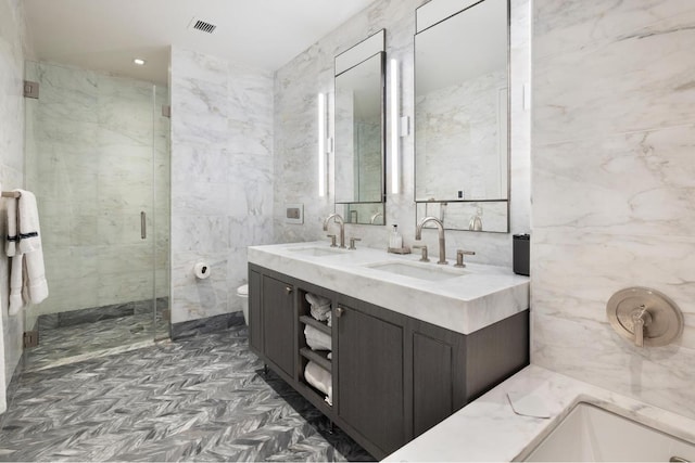 bathroom with tile walls, vanity, a shower with door, and toilet