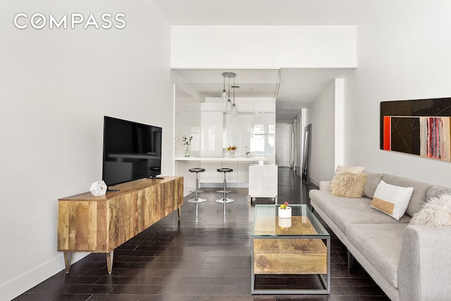 living area featuring dark wood-type flooring and baseboards