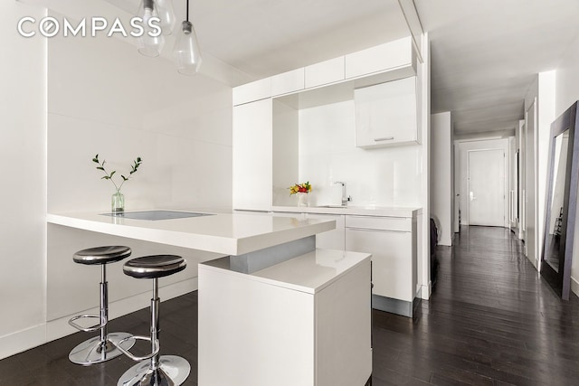 kitchen featuring black electric stovetop, modern cabinets, light countertops, and white cabinetry