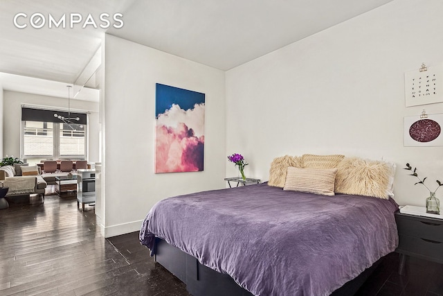 bedroom with baseboards and wood finished floors