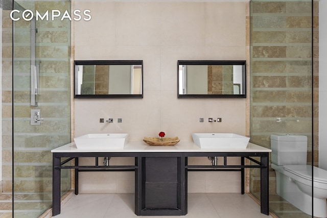 full bath with tile patterned floors, tile walls, and a sink