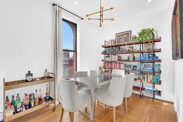 dining room with light hardwood / wood-style flooring and a notable chandelier