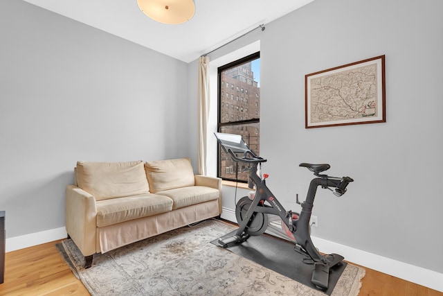 workout room featuring baseboards and wood finished floors