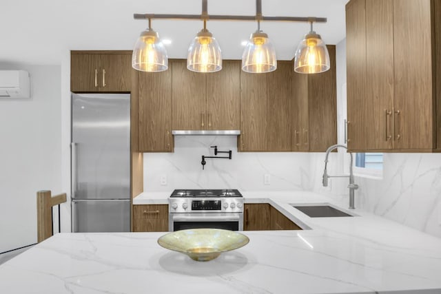 kitchen featuring sink, appliances with stainless steel finishes, a wall unit AC, tasteful backsplash, and decorative light fixtures