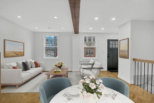 dining space with beam ceiling and light parquet flooring