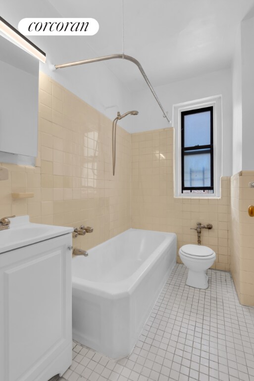 full bathroom with tile walls, tiled shower / bath combo, vanity, and tile patterned flooring