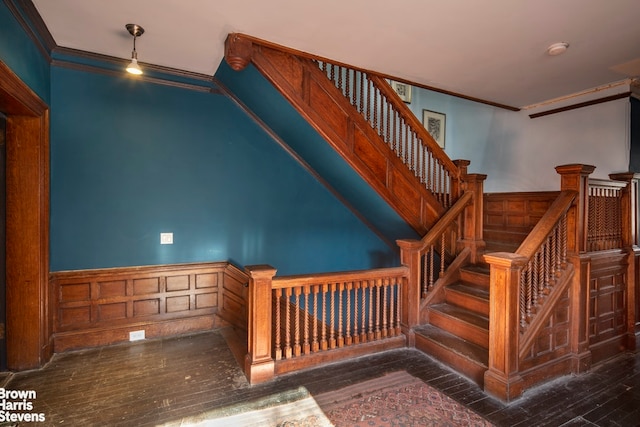 staircase with crown molding and wood-type flooring