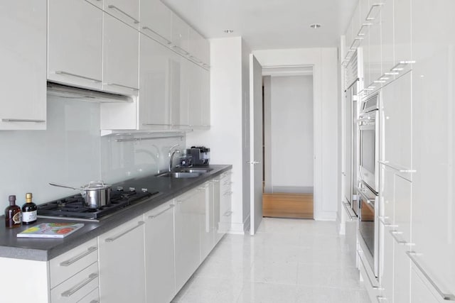 kitchen featuring extractor fan, sink, white cabinets, and stainless steel gas cooktop