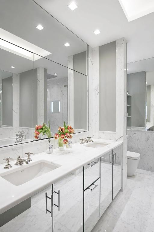 bathroom featuring tile walls, vanity, toilet, and tiled shower