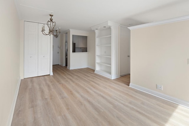 unfurnished living room with a notable chandelier, crown molding, and light wood-type flooring