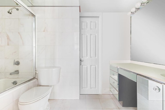 full bathroom featuring tile walls, bath / shower combo with glass door, vanity, tile patterned floors, and toilet