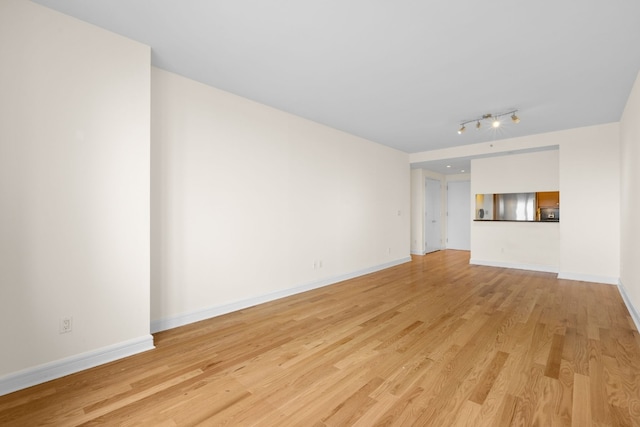 unfurnished living room with track lighting and light hardwood / wood-style floors