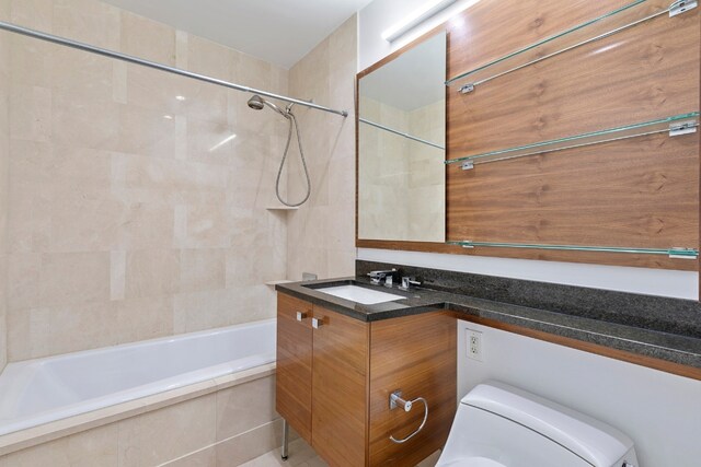 full bathroom with vanity, tiled shower / bath combo, and toilet