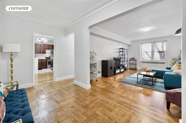 living area featuring radiator, baseboards, visible vents, arched walkways, and ornamental molding