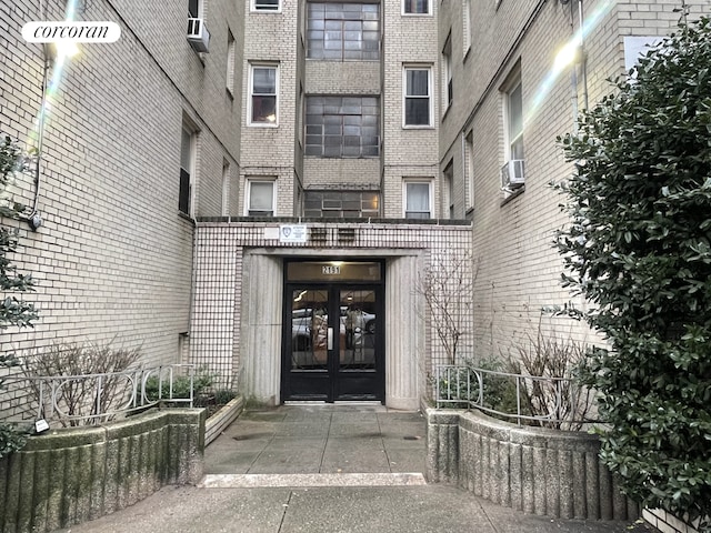 property entrance featuring brick siding, cooling unit, and french doors