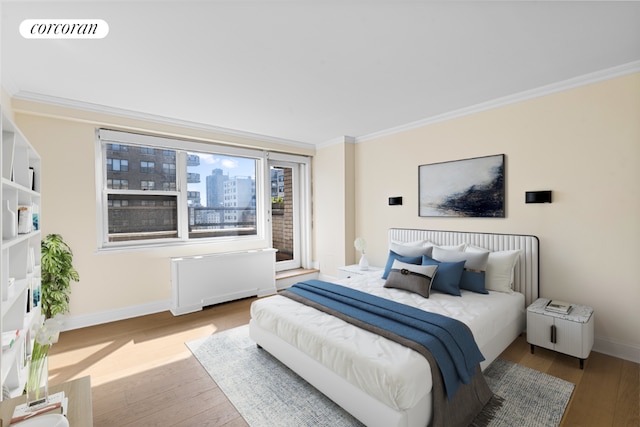 bedroom with light hardwood / wood-style flooring, crown molding, and radiator heating unit