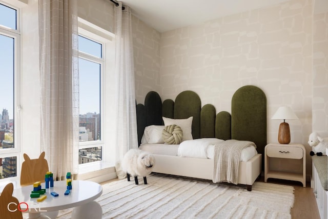 bedroom featuring multiple windows and light hardwood / wood-style flooring