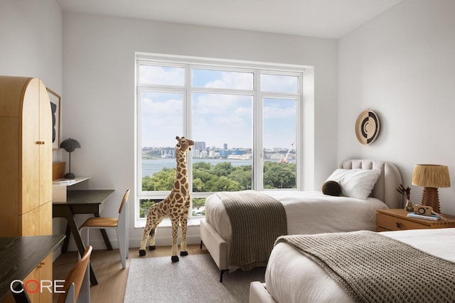 bedroom featuring a water view and light wood-type flooring