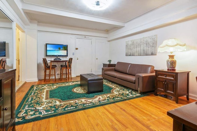 living room with beamed ceiling and wood-type flooring