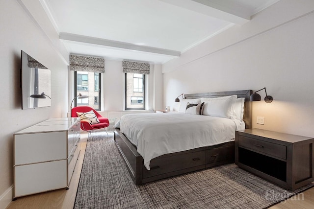 bedroom featuring beam ceiling and light hardwood / wood-style flooring