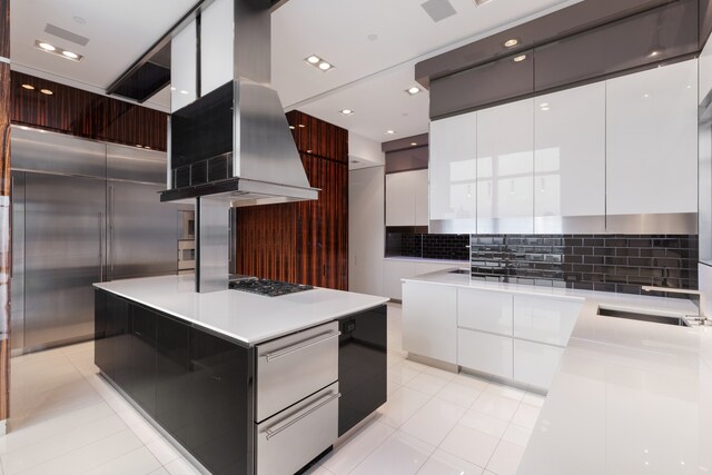 kitchen featuring stainless steel gas stovetop, white cabinetry, a center island, and island exhaust hood