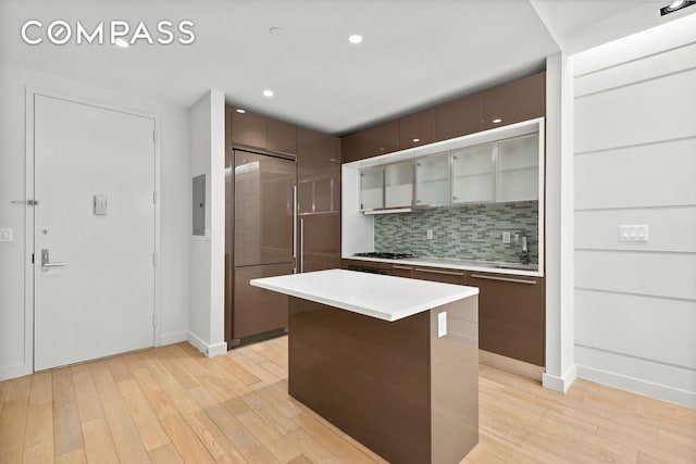 kitchen featuring light countertops, tasteful backsplash, baseboards, light wood-style floors, and recessed lighting
